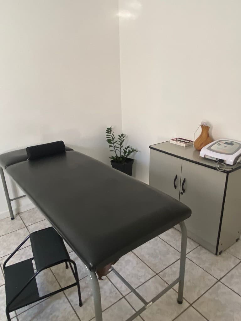 Sala de fisioterapia com maca e equipamentos de tratamento